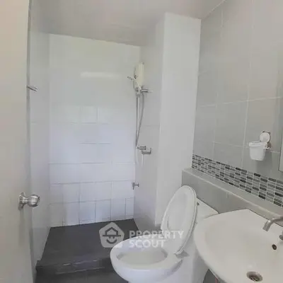 Modern bathroom with sleek shower and contemporary fixtures in a stylish real estate property.