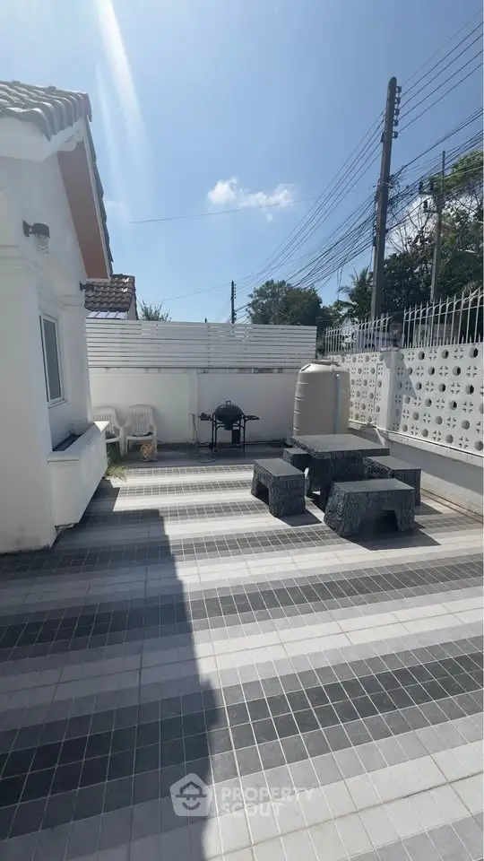 Spacious outdoor patio with BBQ grill and seating area, perfect for entertaining.