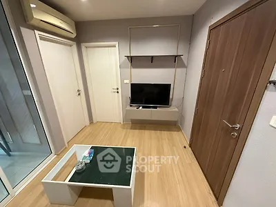 Modern living room with TV, glass coffee table, and air conditioning unit