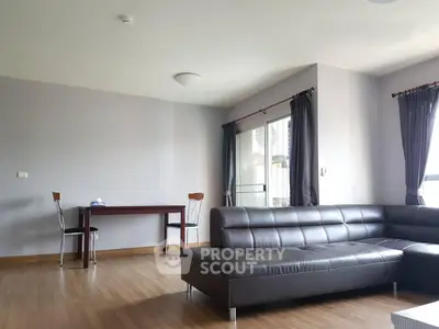 Spacious modern living room with sleek leather sofa and elegant dining area, perfect for urban living.