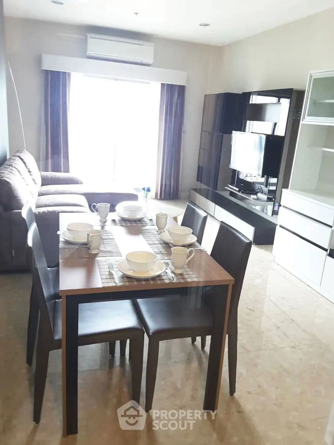 Spacious living room with modern furniture and dining area, perfect for family gatherings.