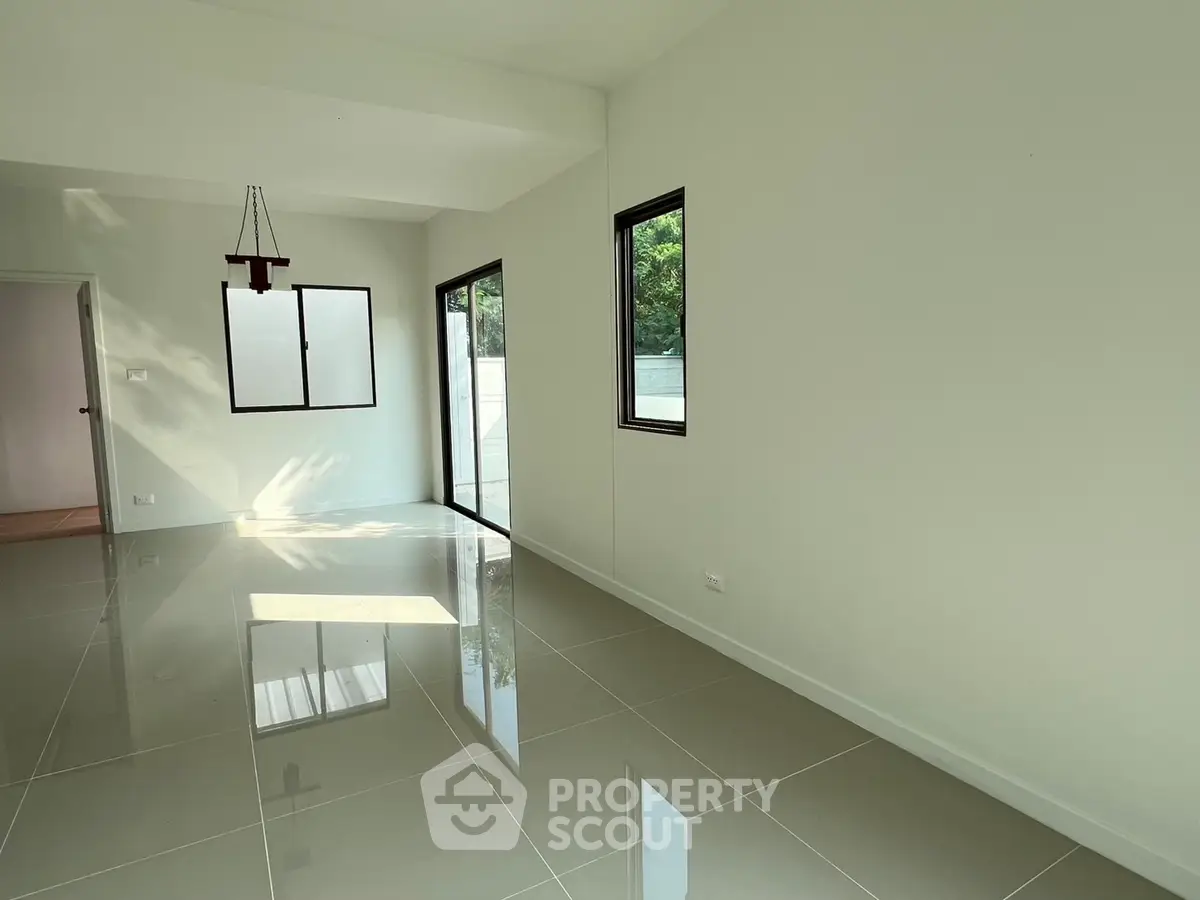 Spacious modern living room with large windows and glossy tiled floors