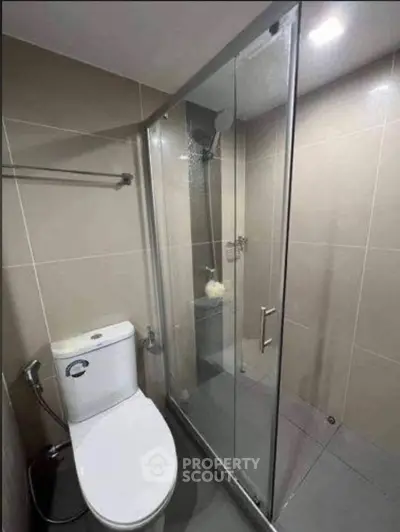 Modern bathroom with glass shower enclosure and sleek fixtures.