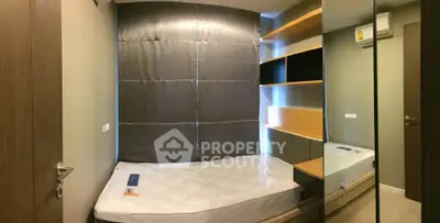 Cozy bedroom with modern design, featuring a comfortable bed and stylish shelving.