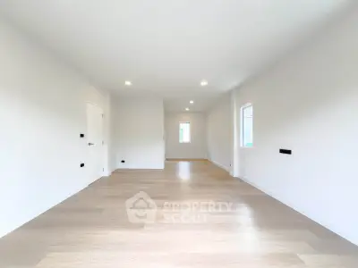 Spacious and bright living room with modern wooden flooring and recessed lighting.