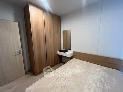 Modern bedroom with sleek wooden wardrobe and cozy bed in minimalist design.