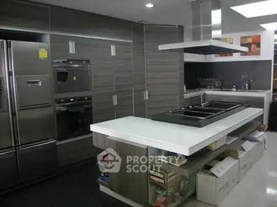 Modern kitchen with sleek cabinetry and island, featuring built-in appliances and contemporary design.