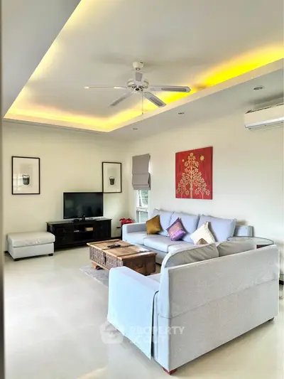 Spacious living room with modern decor, cozy seating, and ambient lighting.