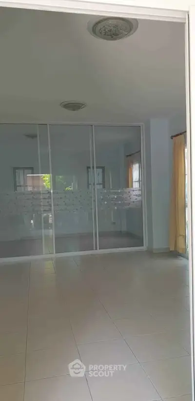 Spacious empty room with large windows and tiled floor, perfect for customization.