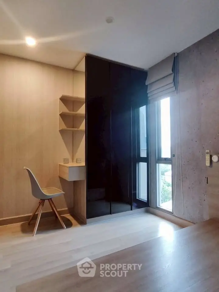 Modern study room with sleek black wardrobe and natural light