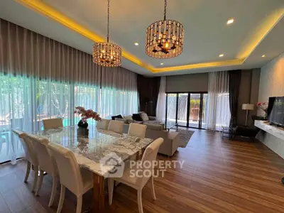 Luxurious open-plan living and dining area with elegant lighting and large windows.