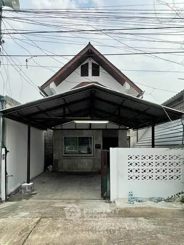 Charming single-family home with covered carport and traditional roof design.