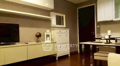 Modern living room with stylish furniture and decor, featuring a TV and dining area.