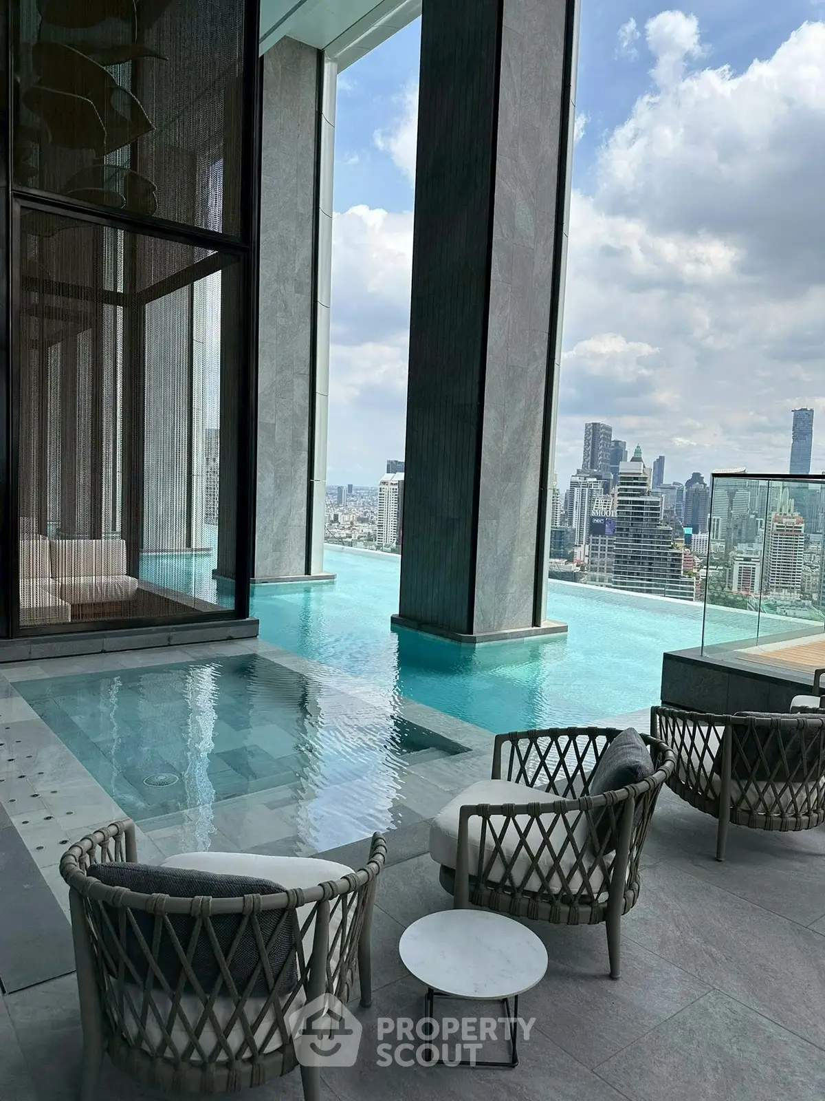 Luxurious rooftop pool with stunning city skyline views and elegant seating area.