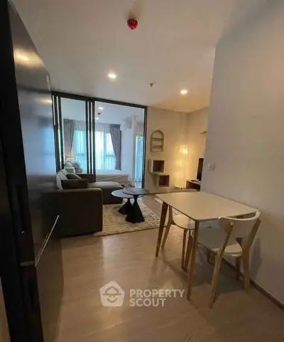 Modern open-plan living room with dining area and cozy seating, featuring elegant decor and natural light.