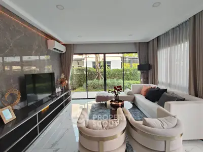 Luxurious living room with modern decor and large windows offering garden view