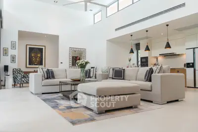 Spacious modern living room with elegant decor and open kitchen layout.