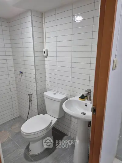 Compact bathroom with white tiles and modern fixtures