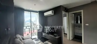 Modern living room with balcony and city view, featuring sleek furniture and air conditioning.