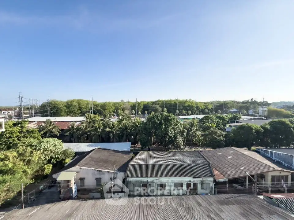 Scenic aerial view of residential area with lush greenery and clear blue sky.