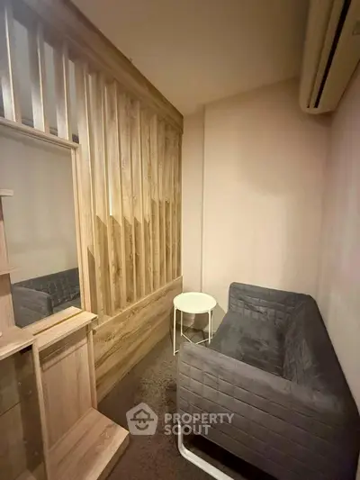 Cozy small living area with modern sofa and wooden accents