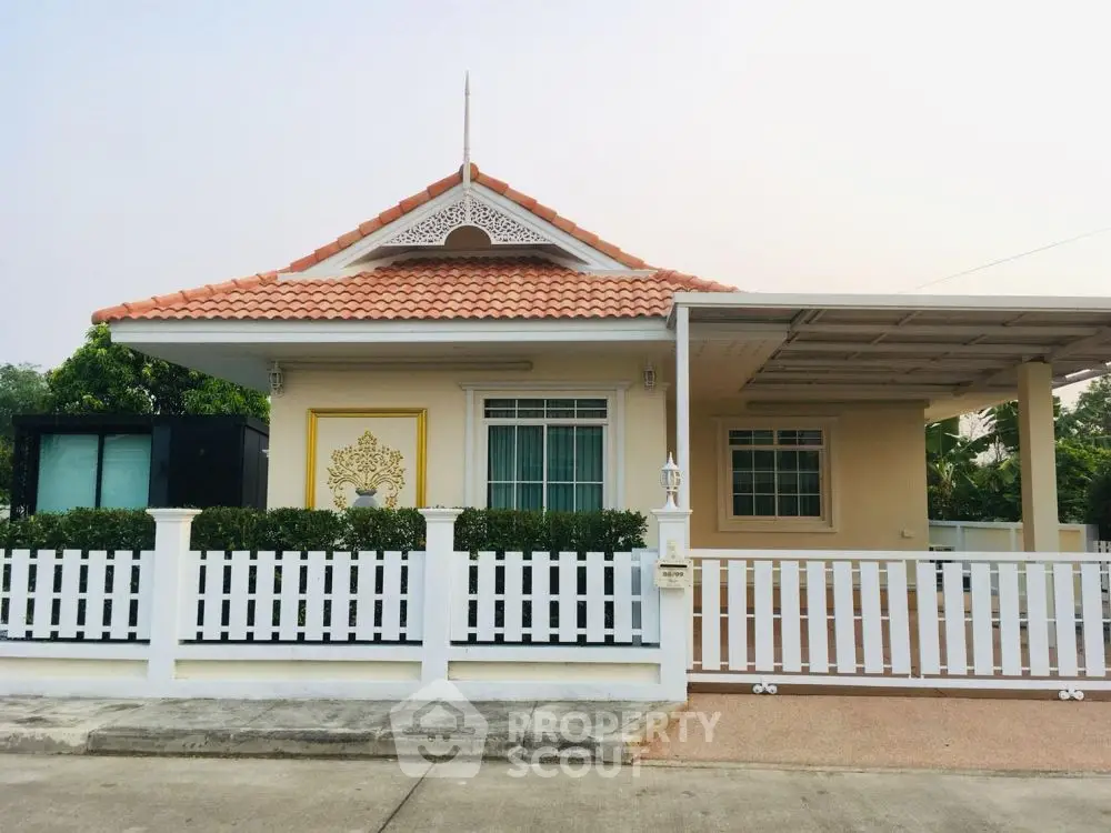 Charming single-story house with white picket fence and carport in serene neighborhood.