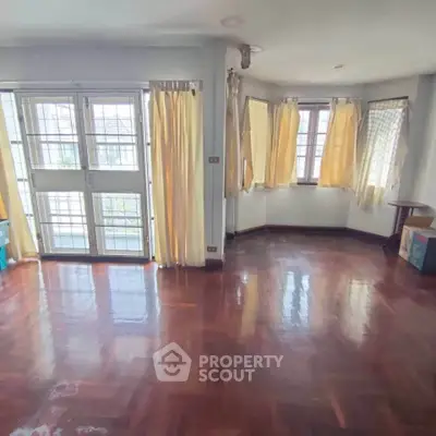 Spacious living room with hardwood floors and large windows for natural light.