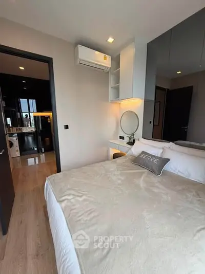 Modern bedroom with cozy bed, air conditioning, and stylish decor in a contemporary apartment.