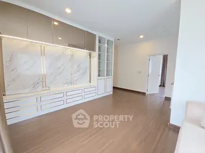 Spacious modern living room with elegant marble accents and ample natural light.