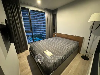 Modern bedroom with large window offering pool view in urban apartment