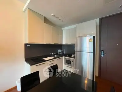 Modern kitchen with sleek cabinetry and stainless steel appliances in a stylish apartment.