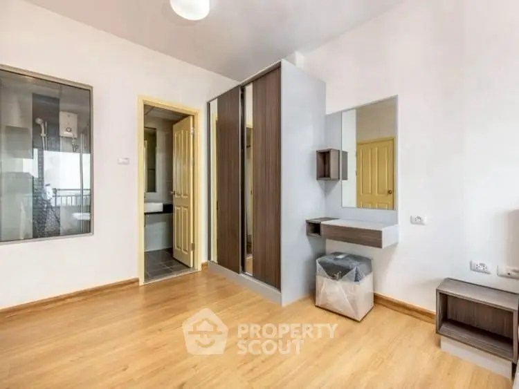 Spacious bedroom with modern wardrobe and wooden flooring