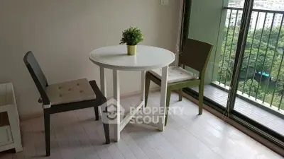 Cozy dining area with round table and chairs next to a large window with a scenic view.