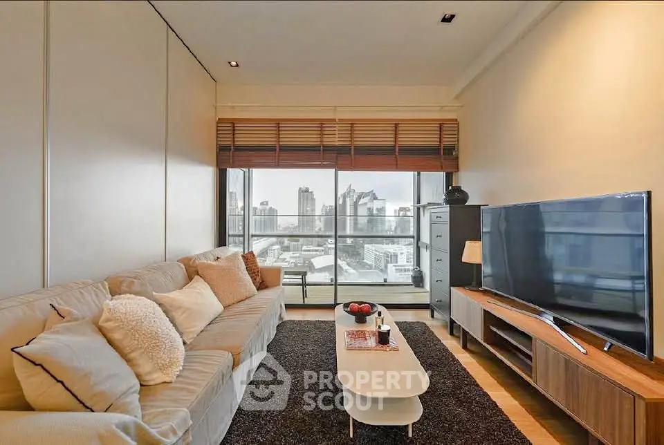 Modern living room with city view, cozy sofa, and large TV setup.