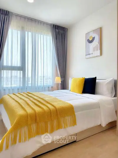 Bright and cozy bedroom with modern decor and large window view.
