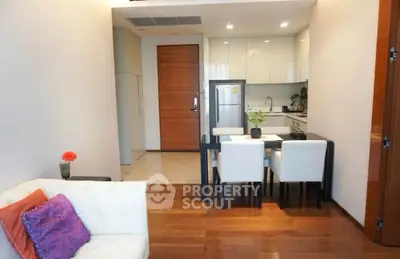 Modern open-layout kitchen and dining area with sleek design and wooden flooring.