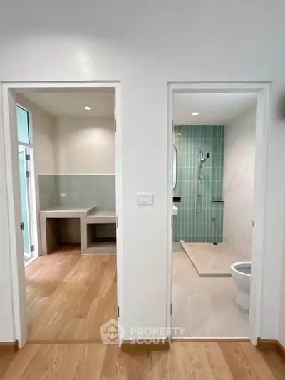Modern bathroom and adjacent room with wooden flooring in a contemporary home.