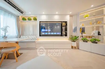 Modern living room with built-in TV, elegant shelving, and stylish decor in a bright, airy space.