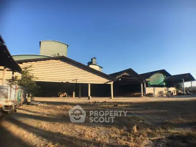 Expansive industrial warehouse with open spaces and clear blue sky, ideal for large-scale operations.