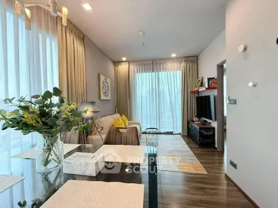 Modern living room with elegant decor and large windows offering natural light.
