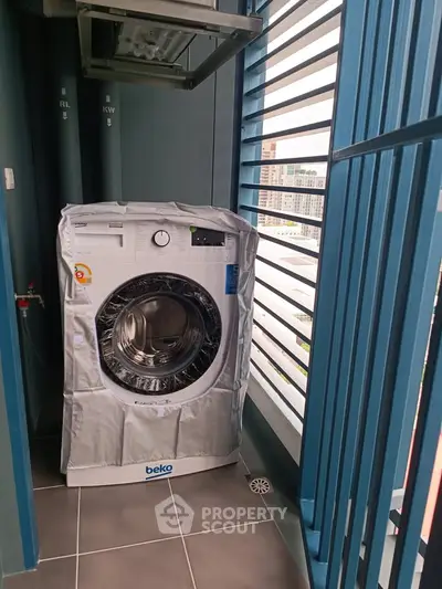 Modern apartment balcony with washing machine and city view, perfect for urban living convenience.