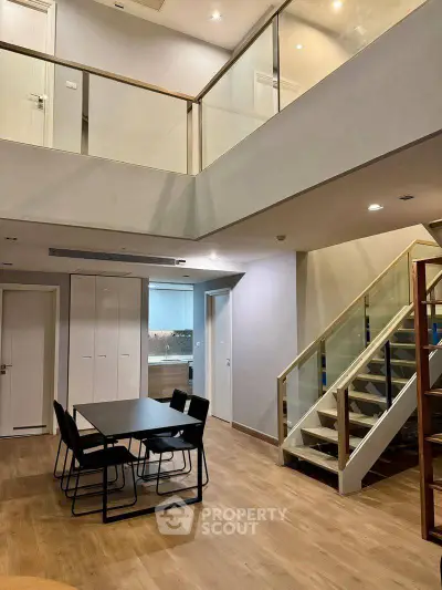 Spacious modern duplex with open dining area and stylish staircase, perfect for contemporary living.