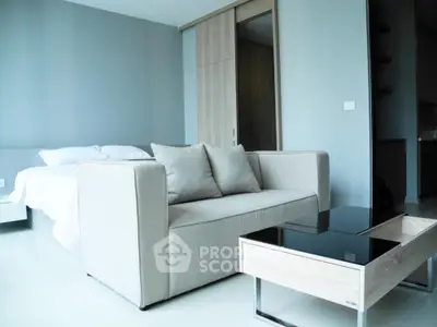 Modern bedroom with cozy sofa and sleek coffee table in a stylish apartment.