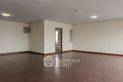 Spacious empty room with wooden flooring and natural light, ideal for customization.