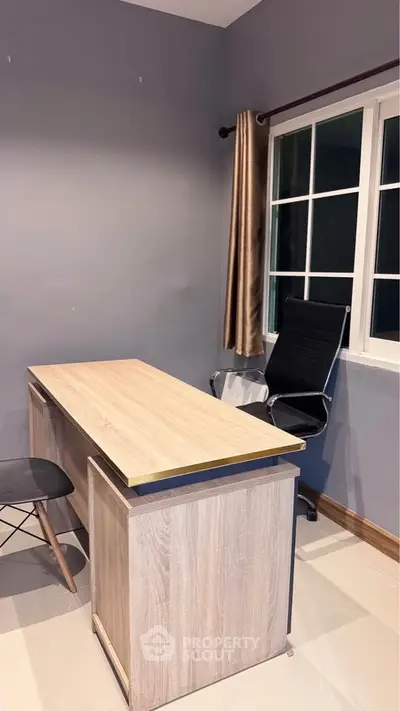 Modern study room with sleek desk and chair, large window with curtains, and minimalist decor.