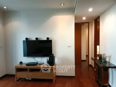 Modern living room with sleek TV setup and wooden flooring in a stylish apartment.