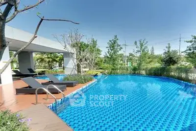 Luxurious outdoor pool area with modern lounge chairs and lush greenery, perfect for relaxation and leisure.