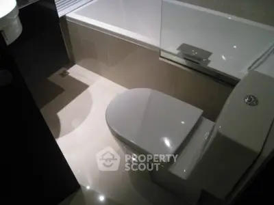 Modern bathroom with sleek toilet and bathtub in contemporary design.