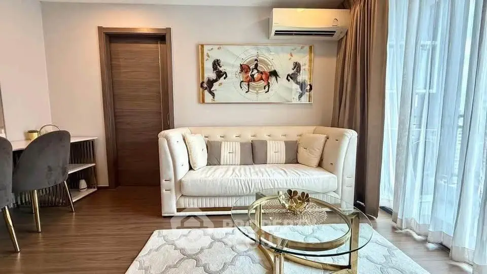 Elegant living room with stylish decor and natural light, featuring a plush sofa and modern artwork.