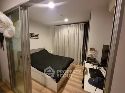 Cozy bedroom with modern decor and sliding glass doors, perfect for urban living.
